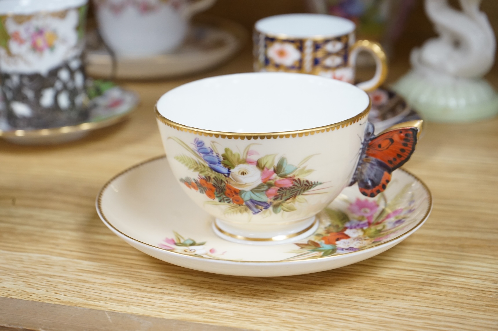 A Worcester butterfly handled cup and saucer and four other items, together with Royal Crown Derby, Dresden and Coalport items. (9). Tallest 13 cm